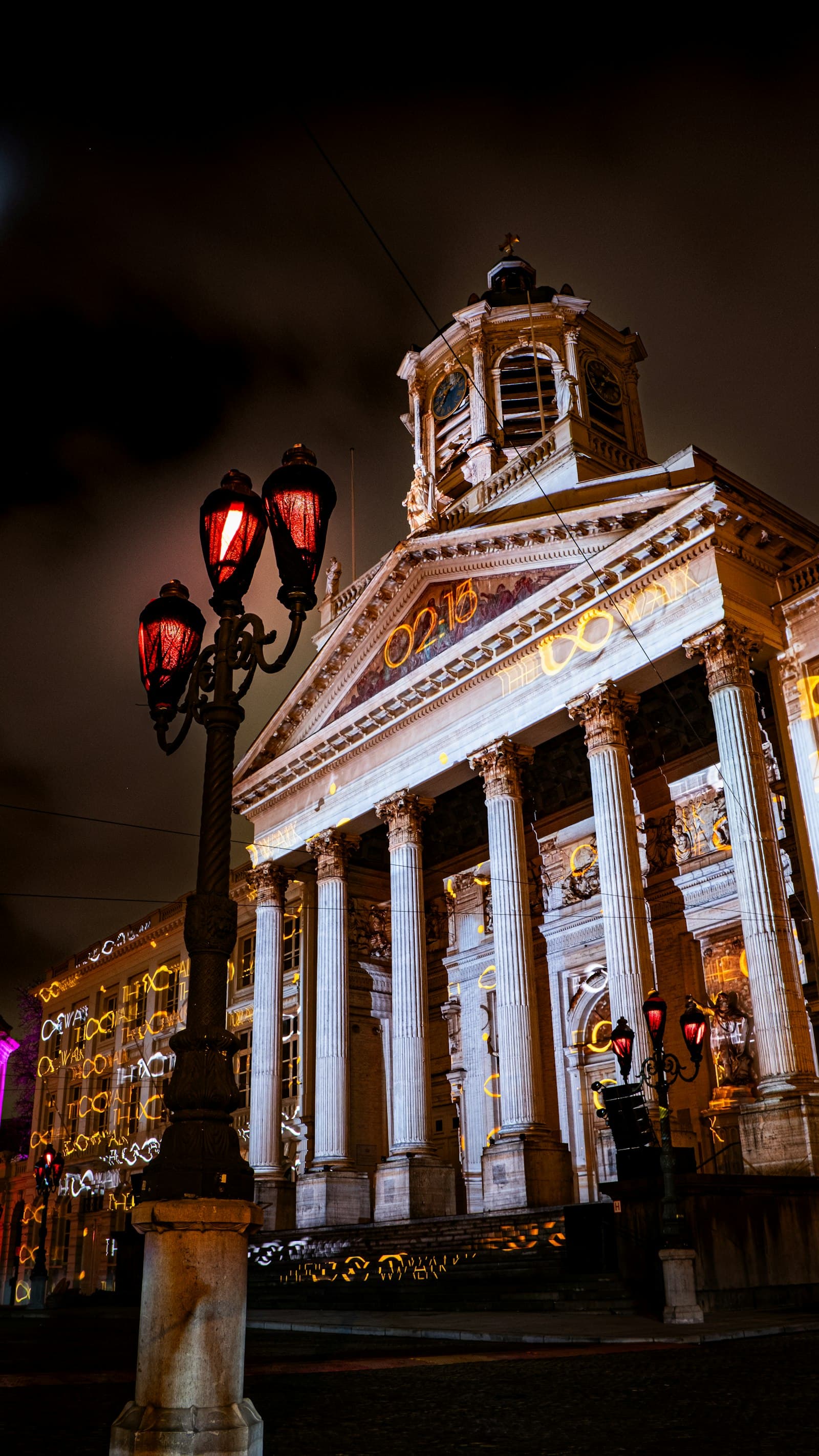 Tipografías luminosas proyectadas sobre palacio de columnas